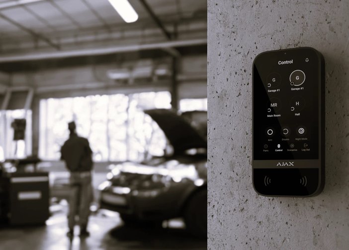Garagebeveiligingssysteem met open motorkap en monteur.